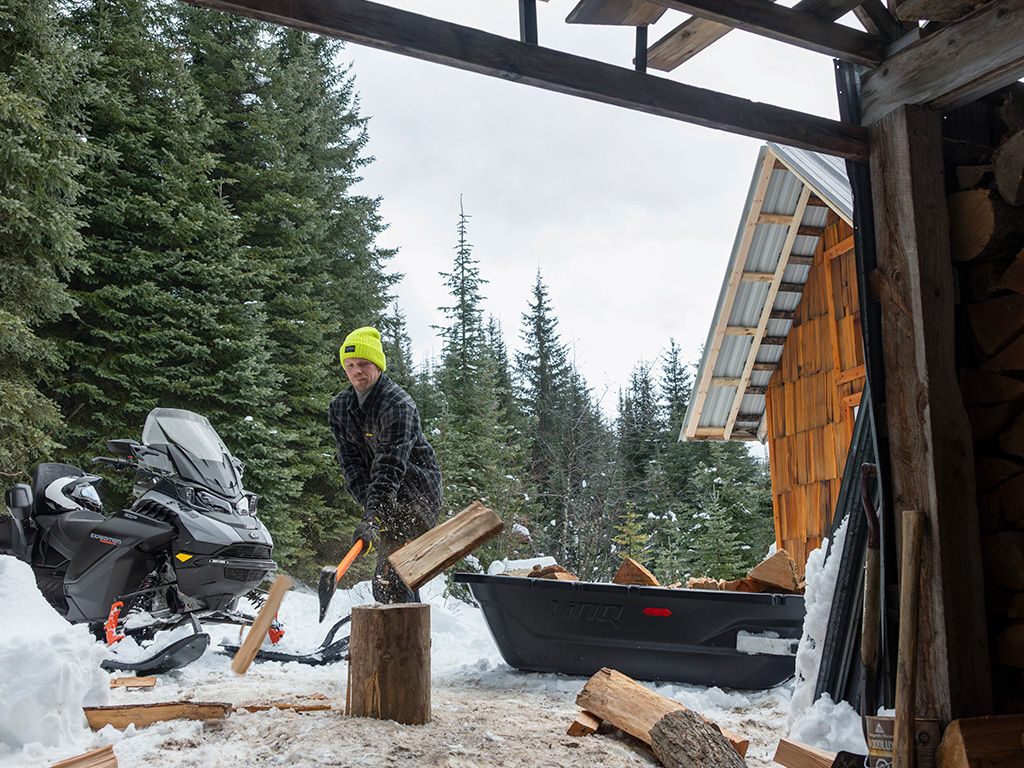Man som hugger ved bredvid en 2027 Ski-Doo Expedition Limited Edition