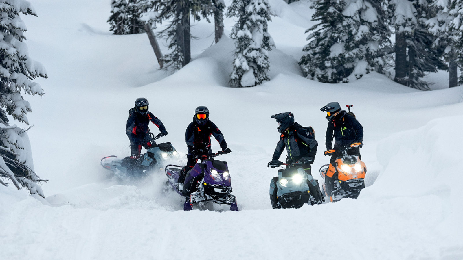 Four riders taking a quick riding break mid-hill on their 2027 Ski-Doo snowmobiles