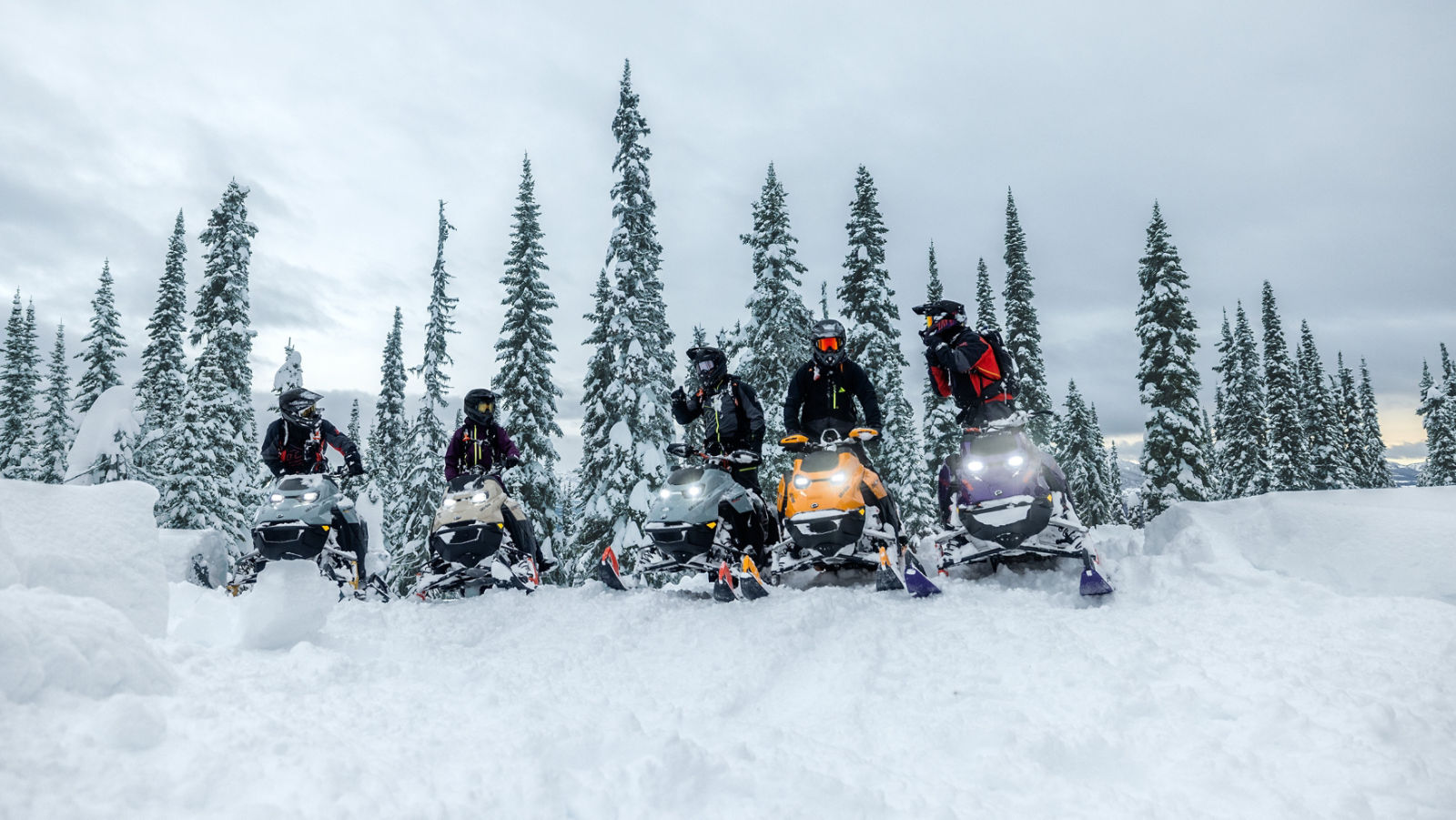 Fem Ski-Doo 2027 djupsnöskotrar stoppade sida vid sida på toppen av en backe