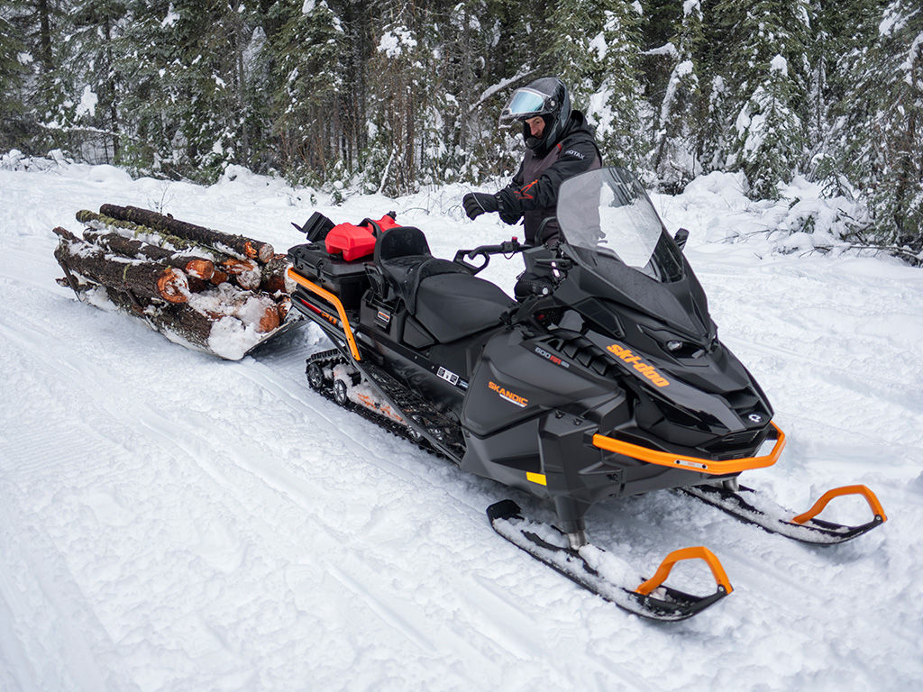 Rider about to ride away on his 2027 Ski-Doo Skandic LE while hauling logs