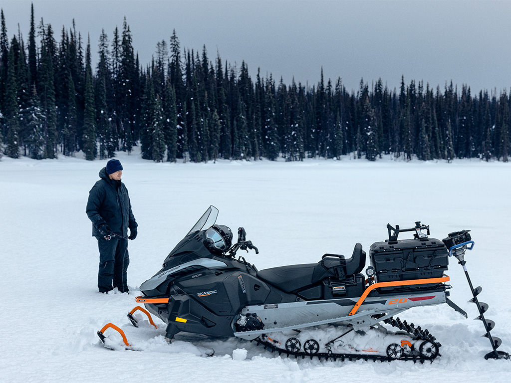 Homme à côté d'un Ski-Doo Skandic SE 2027
