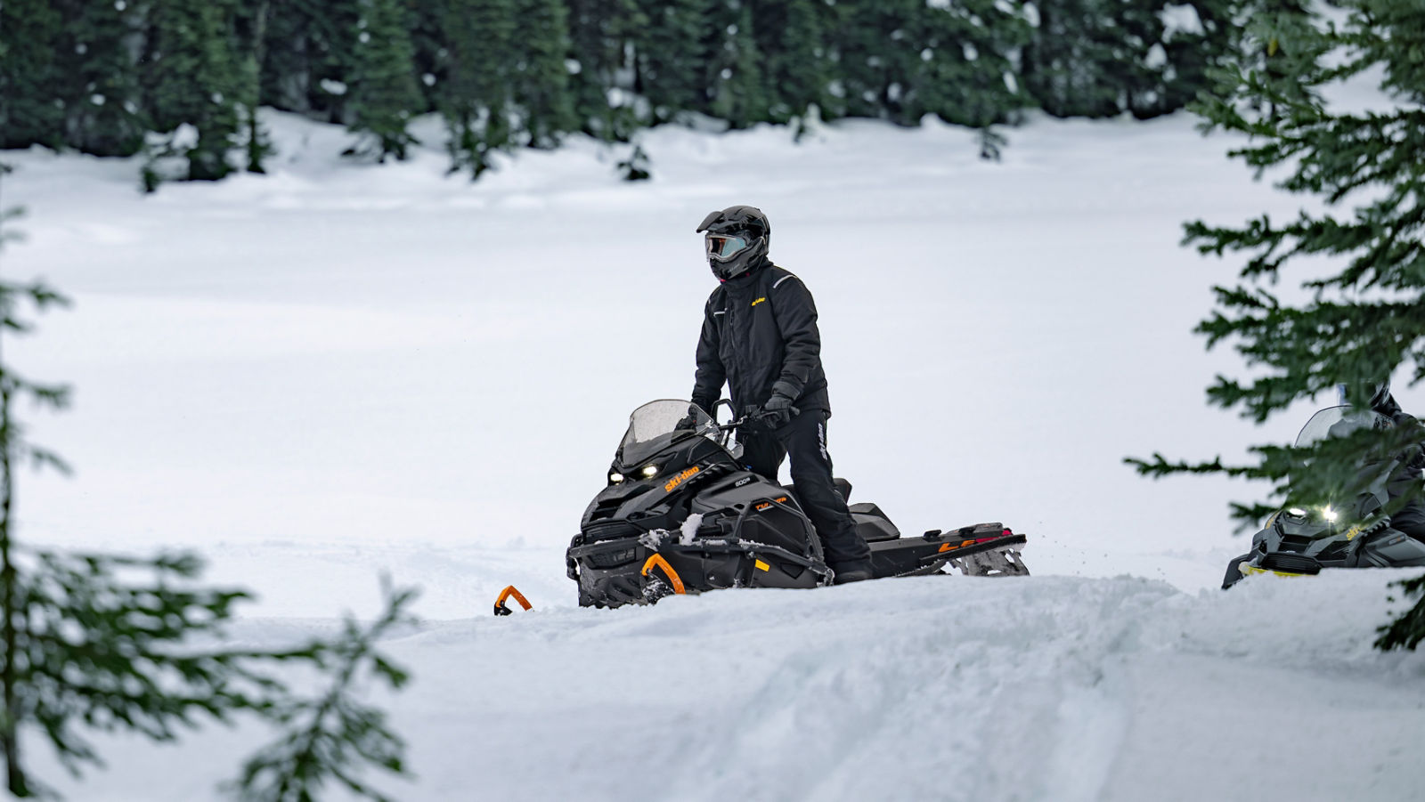 Kaksi 2027 Ski-Doo-hyötykelkkaa ajamassa mäkisessä maastossa