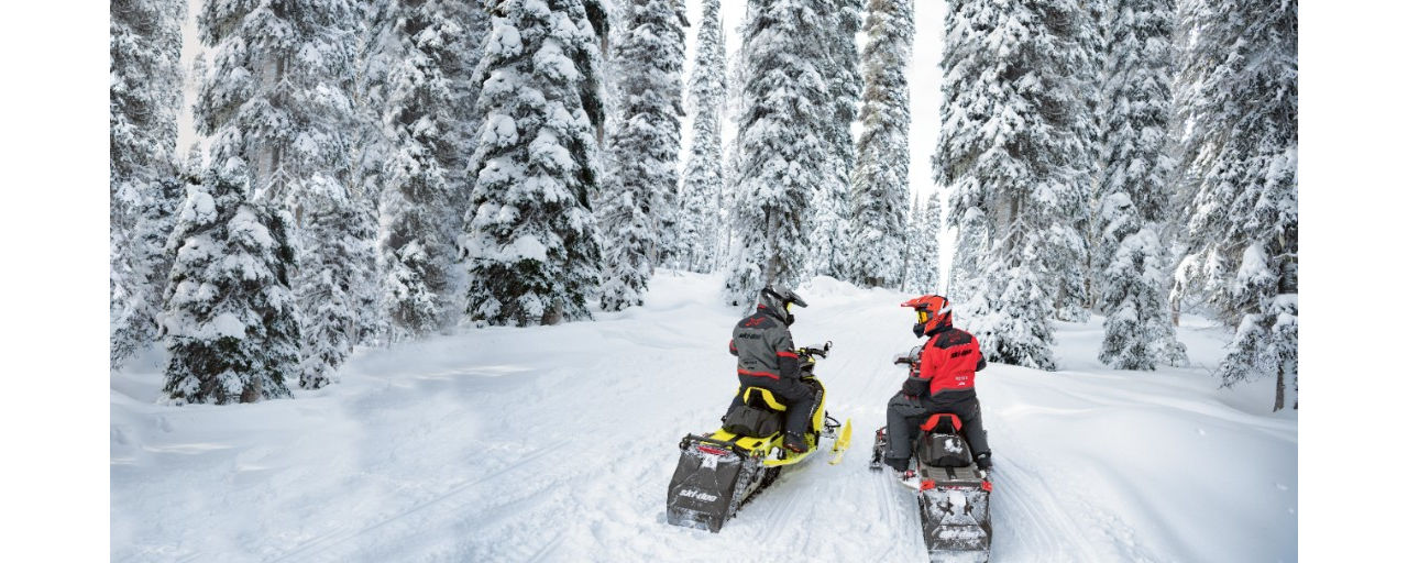 2 personnes sur un Ski-Doo dans les montagnes