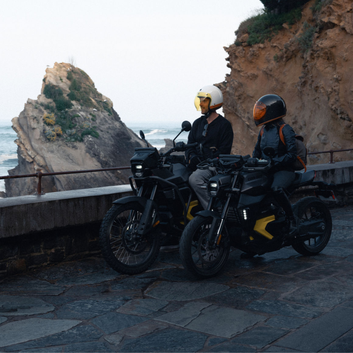 Two motorcyclists sitting on idle Can-Am motorcycles