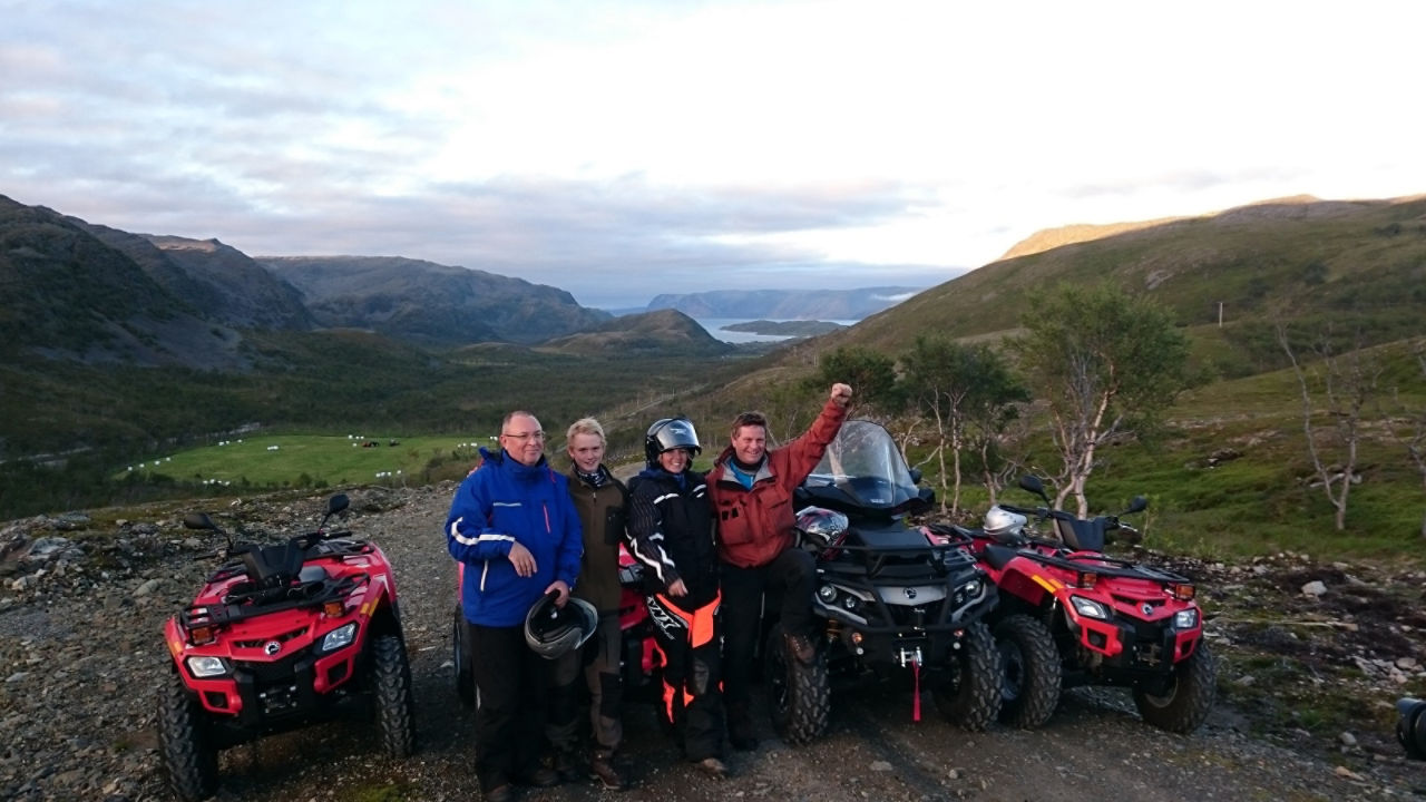 family posing in front of a fjord