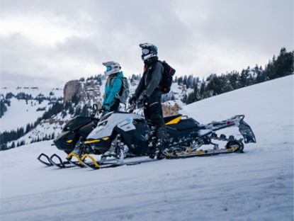 two Ski-Doo riders overlooking a mountain range