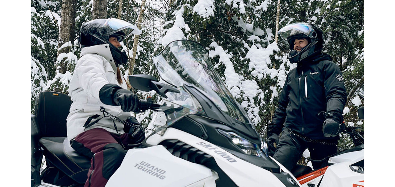 a couple chatting on a Ski-Doo electric snowmobile