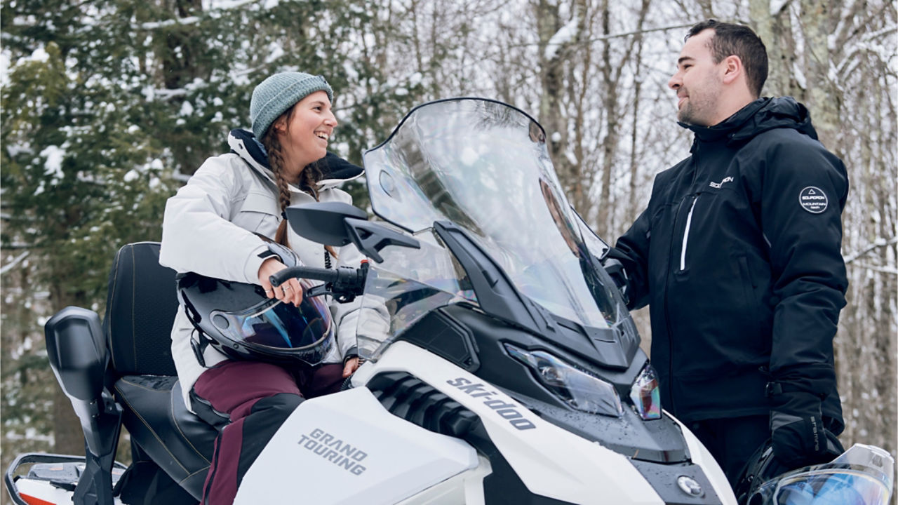 a couple chatting on a Ski-Doo electric snowmobile