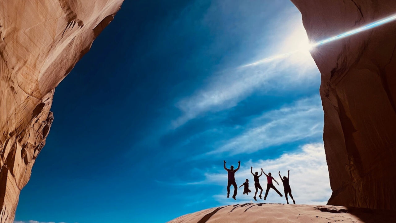 family jumping in the Arches National Park