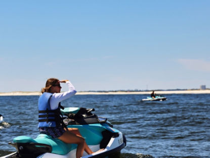 Une femme regardant au loin des dauphins sur un Sea-Doo