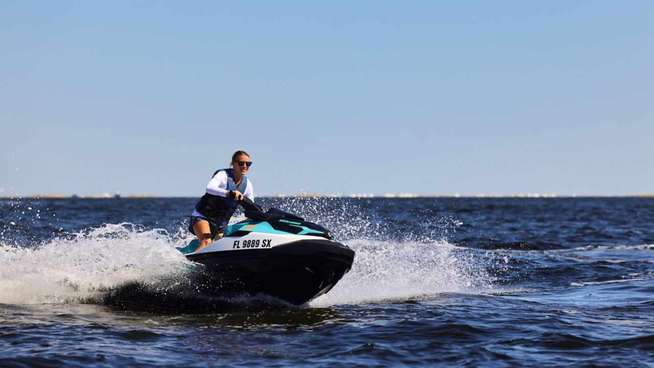 Une femme regardant au loin des dauphins sur un Sea-Doo