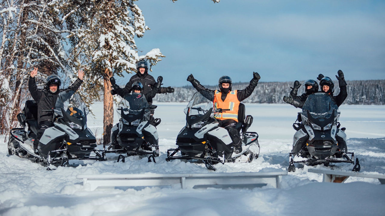 Un groupe de motoneigistes traversant un lac gelé