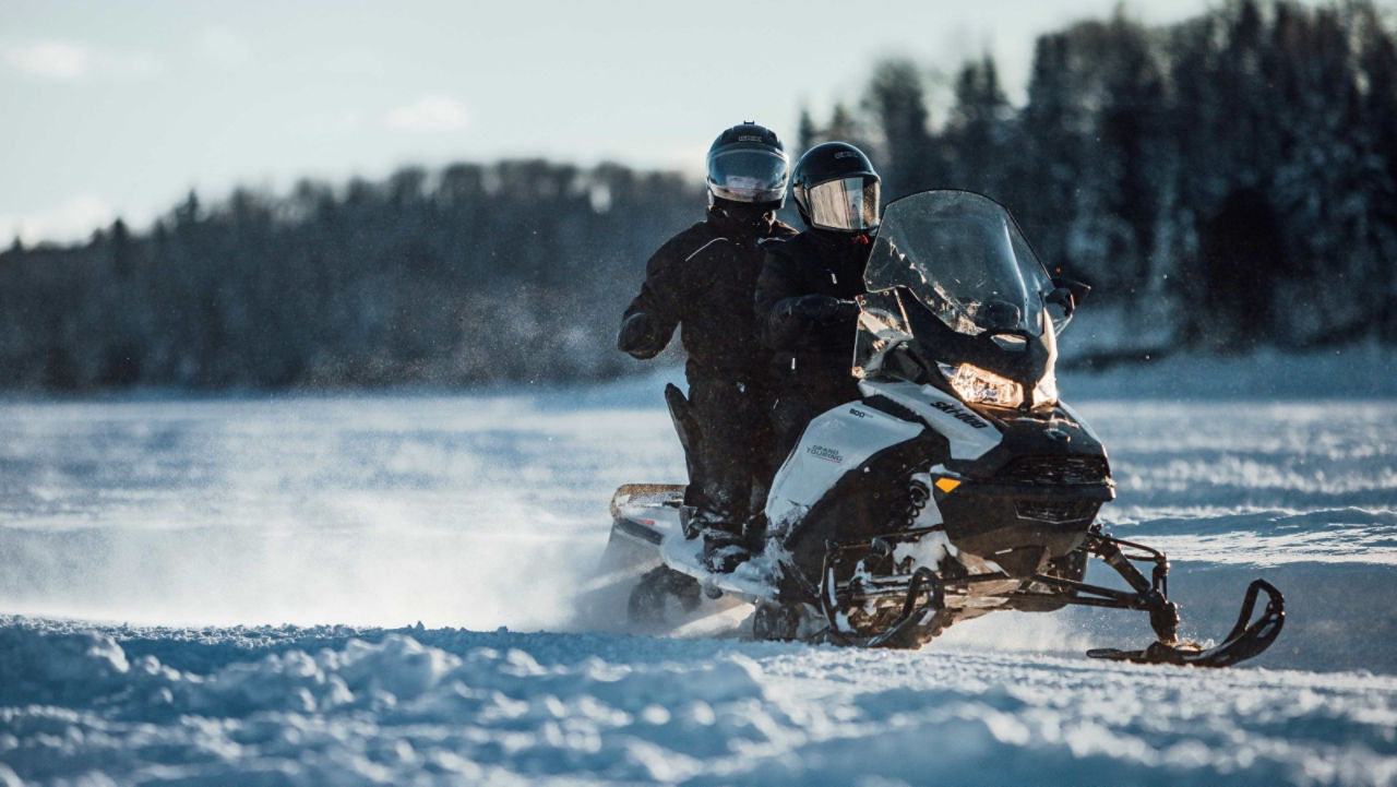 Deux motoneiges traversant un lac gelé