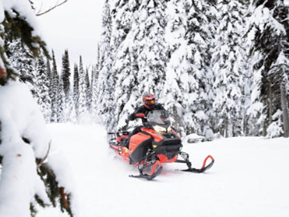 Un motoneigiste conduisant un Ski-Doo sur un sentier