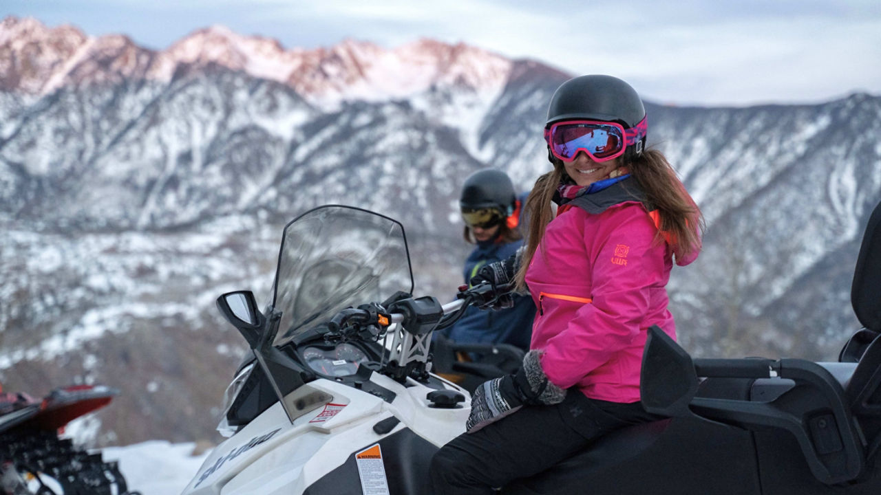 Un homme heureux conduisant un Ski-Doo sur de la neige fraîche.