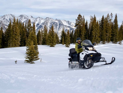 Un homme heureux conduisant un Ski-Doo sur de la neige fraîche.