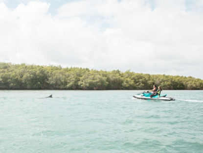 Mère et fille sur une motomarine regardant les dauphins nager