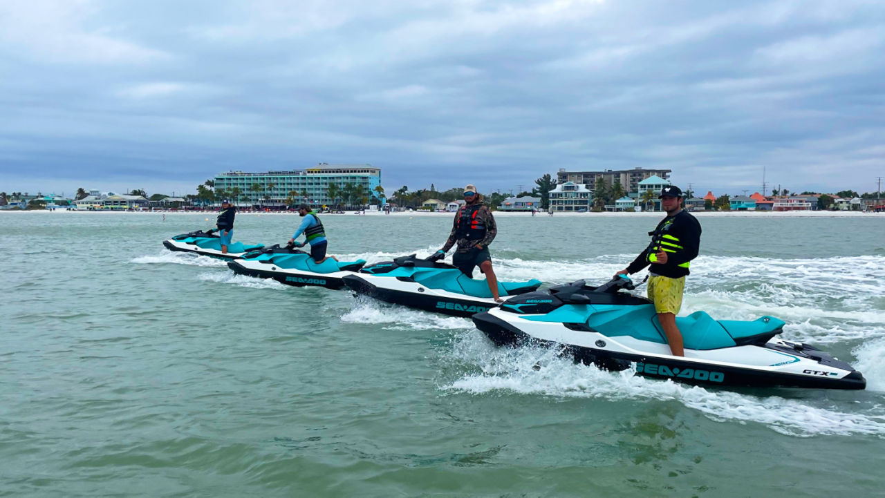 Vue latérale de quatre pilotes de Sea-Doo dans l'eau