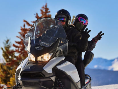 couple faisant le signe de la main sur un Ski-Doo