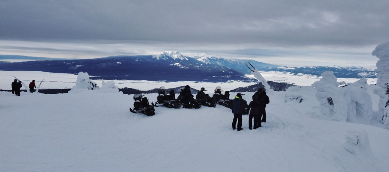 Motoneigistes admirant la vue sur les montagnes