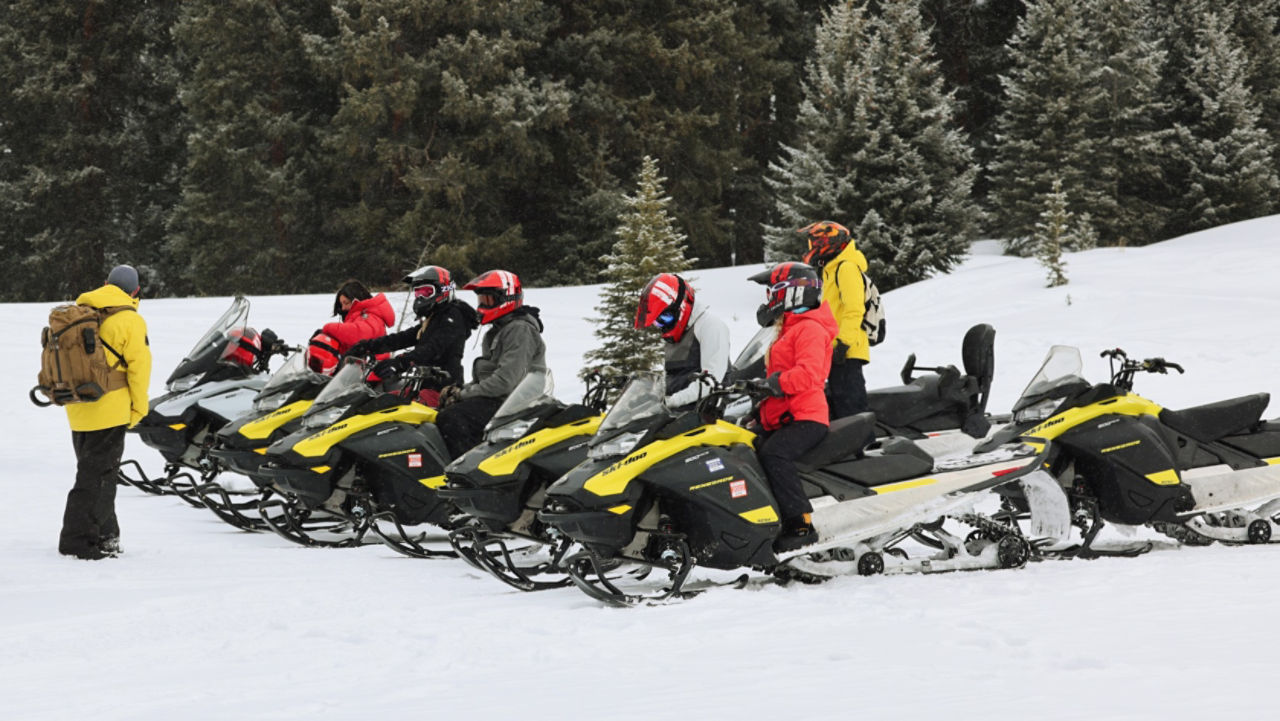 groupe de pilotes de ski-doo au coucher du soleil