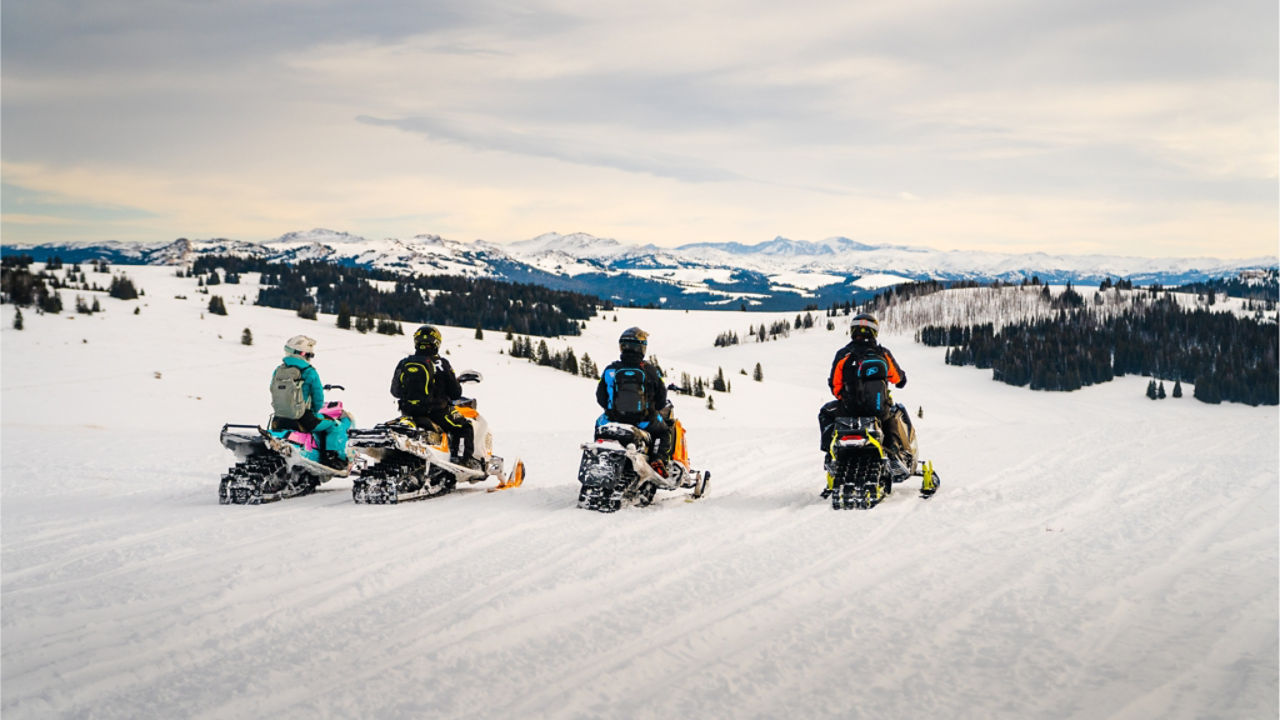 groupe de pilotes de ski-doo au sommet d'une crête