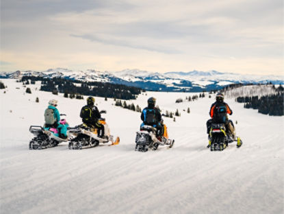 groupe de pilotes de ski-doo au sommet d'une crête