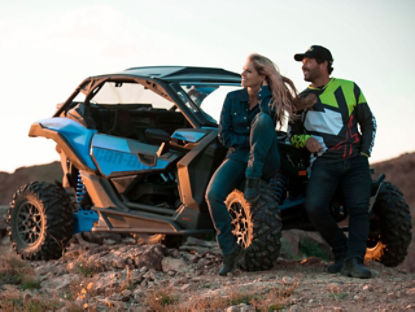 Un couple se reposant à côté d'un véhicule Can-Am Off-Road