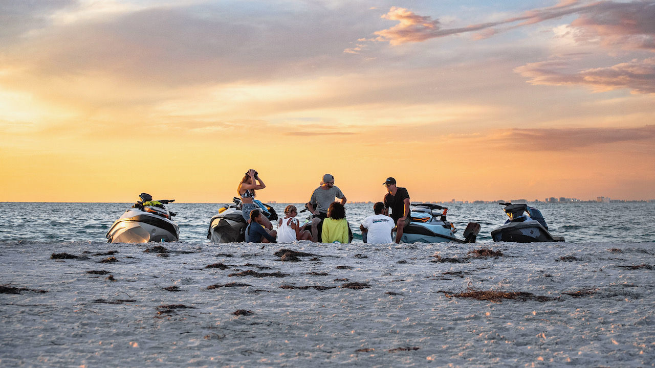 Group of friends on the beach with Sea-Doo personal watercraft