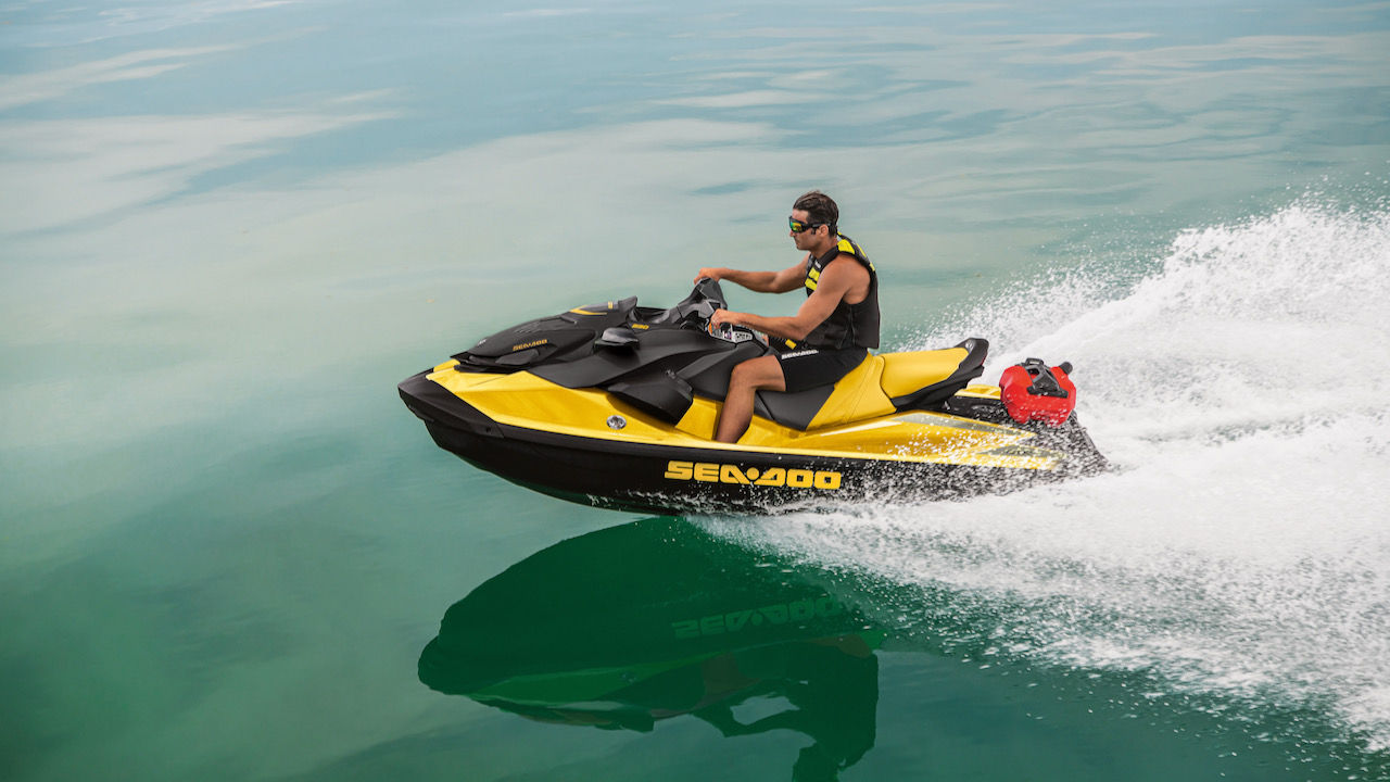 Un homme tournant avec une motomarine Sea-Doo avec une île en arrière-plan