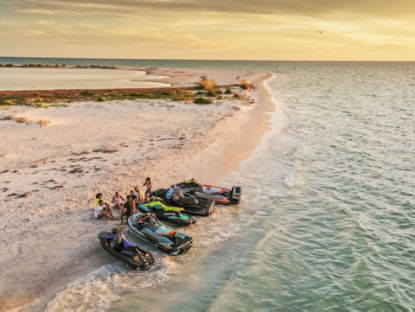 Amis sur une plage avec des motomarines garées