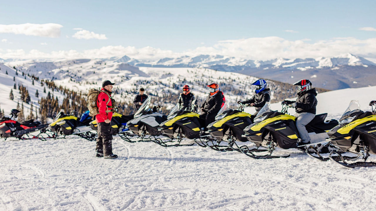 groupe de pilotes de ski-doo au sommet d'une crête