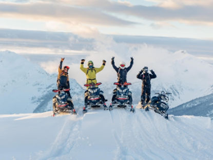 groupe de pilotes de Ski-Doo au sommet de la montagne