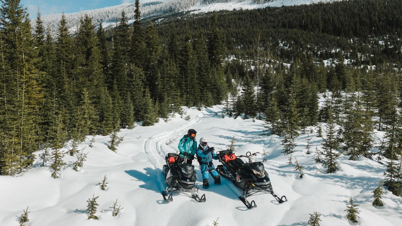 groupe de pilotes de Ski-Doo au sommet de la montagne