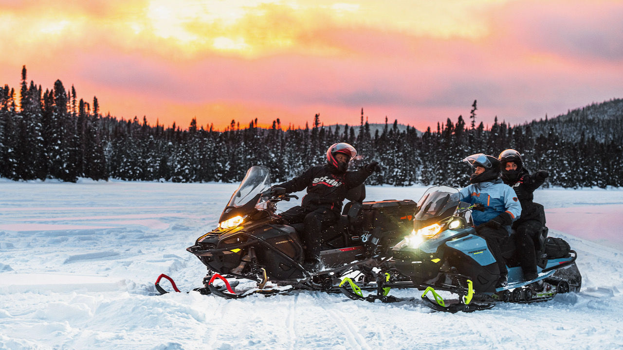 groupe de pilotes de ski-doo au coucher du soleil